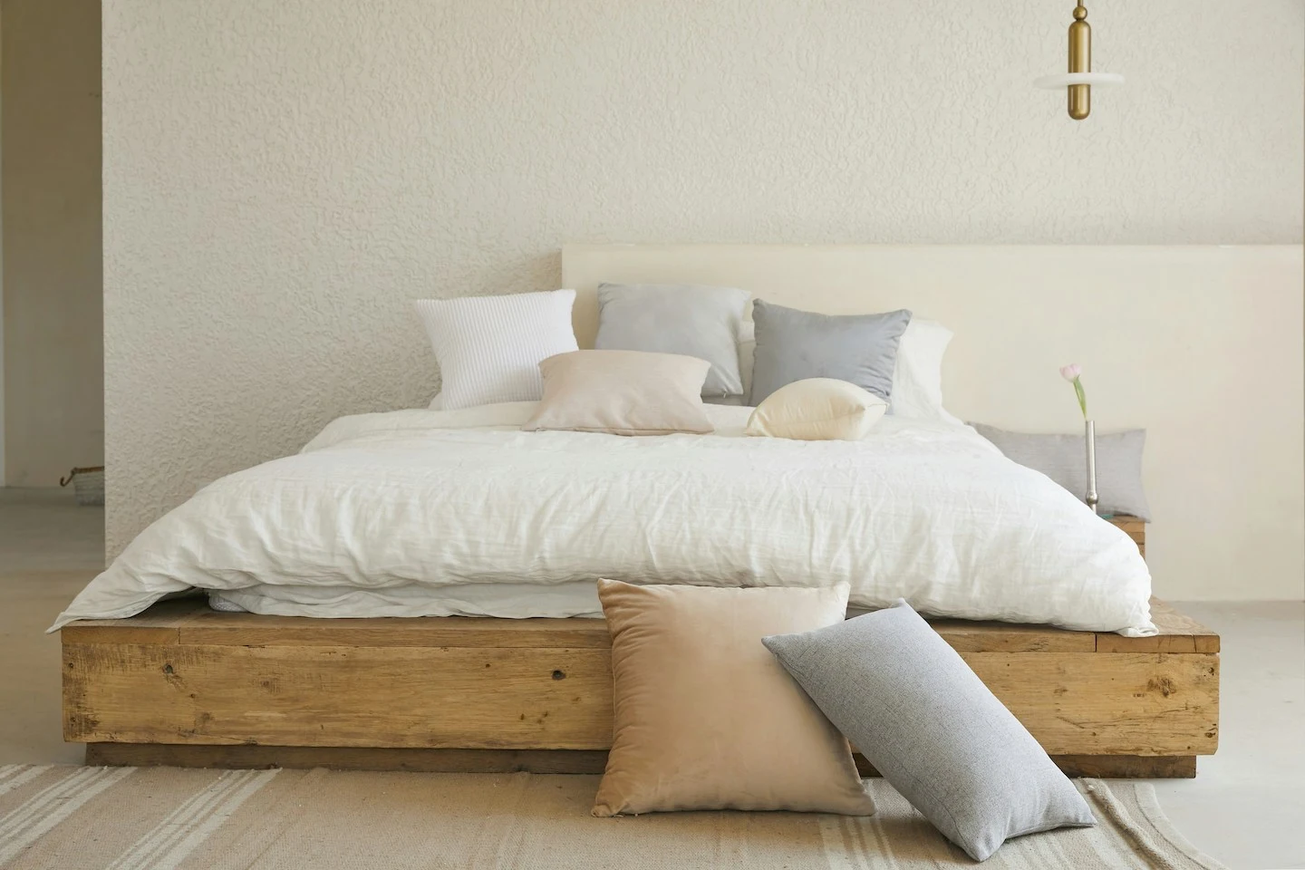 Airbnb bedroom with fresh white linens and pastel pillowcases.
