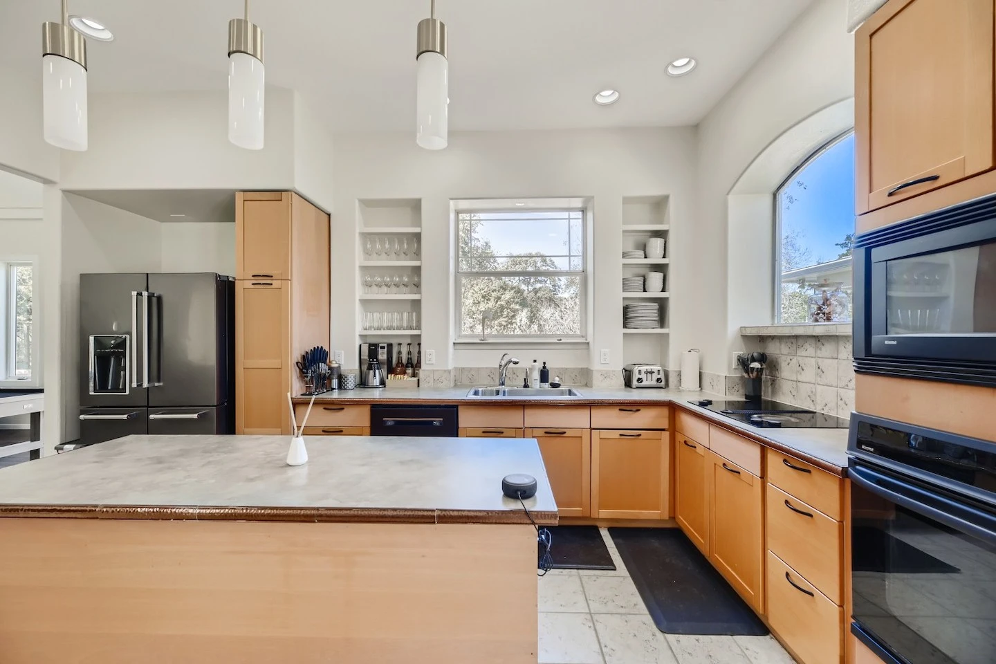 Airbnb kitchen in Austin stocked with essential items like glasses, cups, plates, and a toaster.
