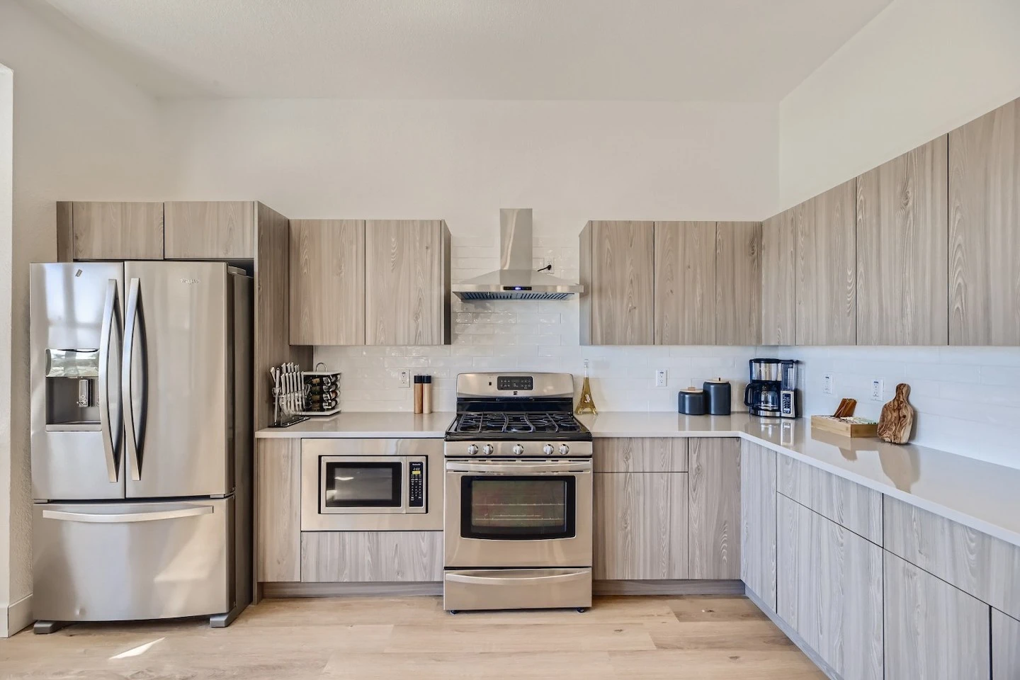 Austin Airbnb kitchen with essentials including coffee maker, sugar, and cutting boards.